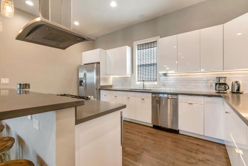 a kitchen with white cabinets and stainless steel appliances at New Construction Elegant Villas in New Orleans