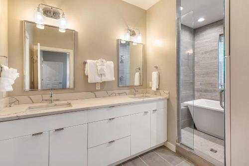 a bathroom with two sinks and a shower at New Construction Elegant Villas in New Orleans