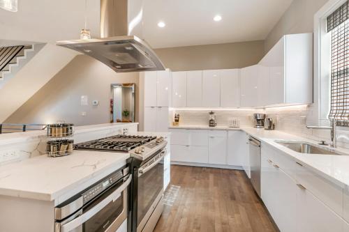 a kitchen with white cabinets and a stove top oven at New Construction Elegant Villas in New Orleans