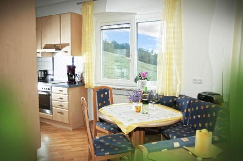a kitchen with a table and chairs and a kitchen with a window at Haus Steinfeld in Kirchberg an der Raab