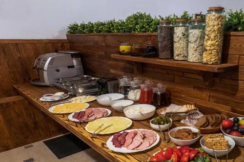 a table topped with plates of meat and other food at Geneva Resort Hotel in Odesa