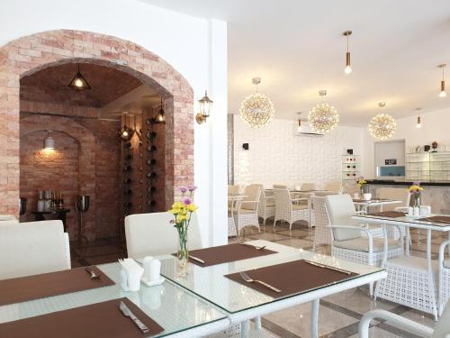 a restaurant with white tables and chairs and a brick wall at Marina Point Bay Resort in Panglao