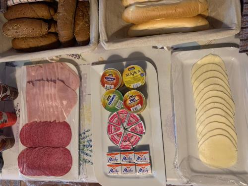 a refrigerator filled with different types of cheese and bread at Rekreačný dom SISI in Podhájska