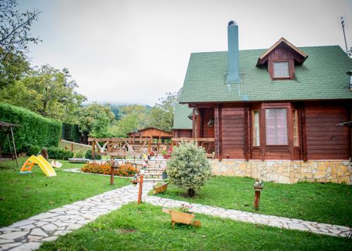 a log house with a playground in front of it at Kedra Village in Kédra