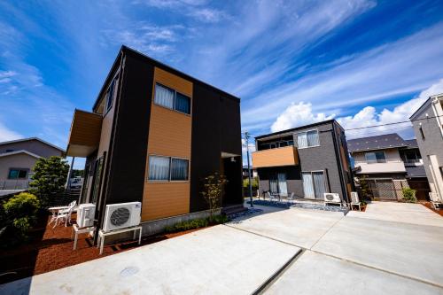 a black and orange building with chairs in front of it at 21 ORIYA Mt Fuji -縁ENISHI- in Fujikawaguchiko