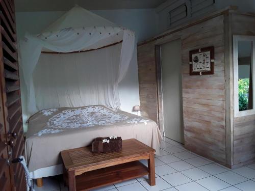 a bedroom with a bed and a table with a bag on it at Les Gites De Robinson in Conception