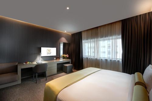 a hotel room with a bed and a desk at 72 Hotel Sharjah in Sharjah