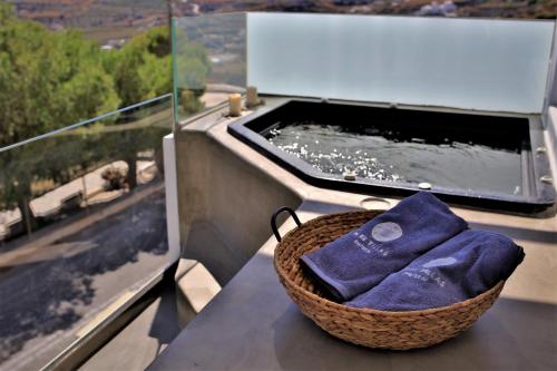 a basket of towels sitting on a counter next to a bath tub at A Lux Villas Santorini in Éxo Goniá