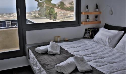 een slaapkamer met een bed met 2 kussens erop bij A Lux Villas Santorini in Éxo Goniá