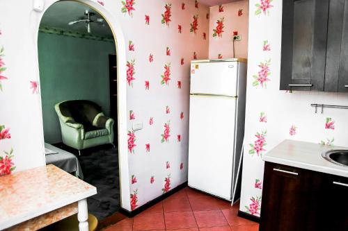 a kitchen with a refrigerator with flowers on the wall at Апартаменты Кирова, 83 in Rakitnyy