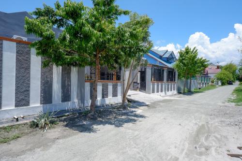 a tree in a street next to a building at RedDoorz Syariah near Mutiara SIS Al Jufrie Airport Palu 2 in Palu