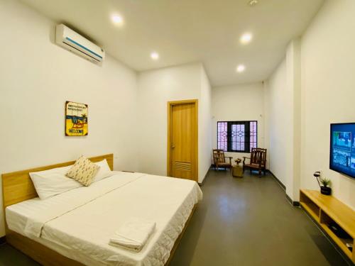 um quarto com uma cama grande e uma televisão em Vitamin Sea Homestay Nha Trang em Nha Trang