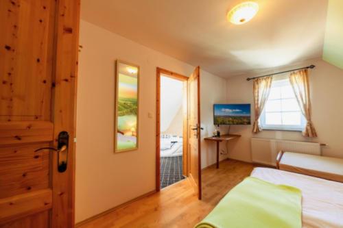 ein Schlafzimmer mit einem Bett und einer Tür zu einem Bad in der Unterkunft Kellerstöckl Goigner in Kitzeck im Sausal