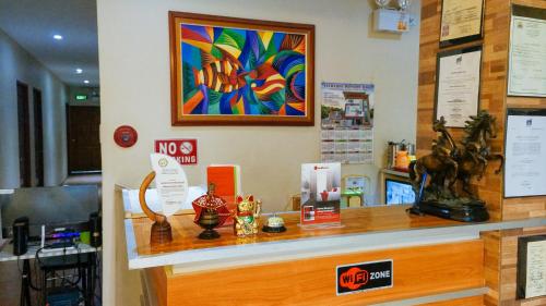 a shop with a counter with a colorful painting on the wall at RedDoorz near Talisay District Hospital in Candulawan
