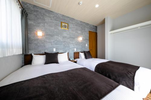 dos camas sentadas una al lado de la otra en una habitación en 21 ORIYA Mt Fuji -縁ENISHI-, en Fujikawaguchiko
