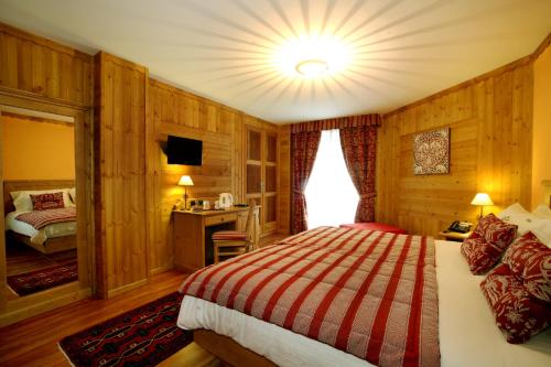 a hotel room with a bed and a television at Hotel Boton D'Or & Wellness a La Thuile in La Thuile