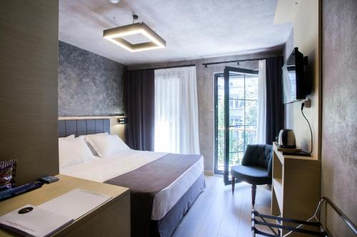 een hotelkamer met een bed, een bureau en een raam bij Red Stone Hotel in Istanbul