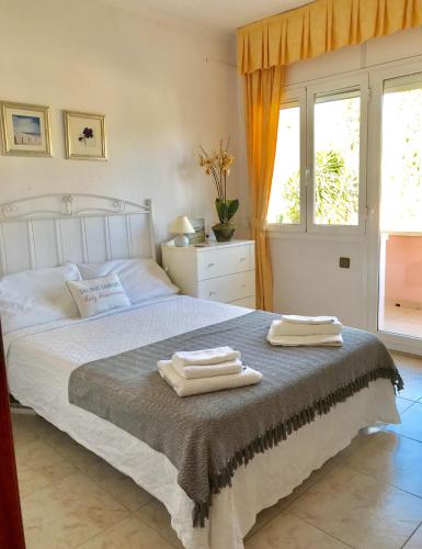 a bedroom with a bed with two towels on it at Villa Rosa Sitges in Can Trabal