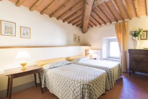 a bedroom with two beds and a table at Appartamenti Catarsena in Banzena