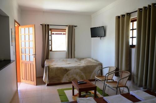 1 dormitorio con 1 cama, 2 sillas y mesa en Pousada Vila Arco-Iris, en Porto de Sauipe