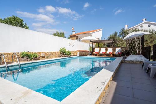 a swimming pool with blue water in a house at Akivillas Sesimbra Ocean in Lagoa de Albufeira