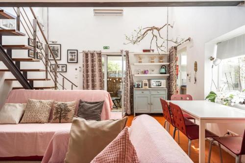 a living room with a pink couch and a table at Akivillas Sesimbra Ocean in Lagoa de Albufeira