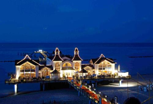 a large building on the beach at night at WG Bernstein - Reetdachhaus - Ruhe und Seeblick in Ostseebad Sellin