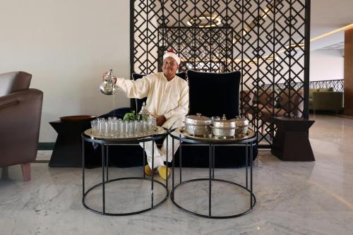a man sitting in a chair next to a table at Kenzi Rose Garden in Marrakech