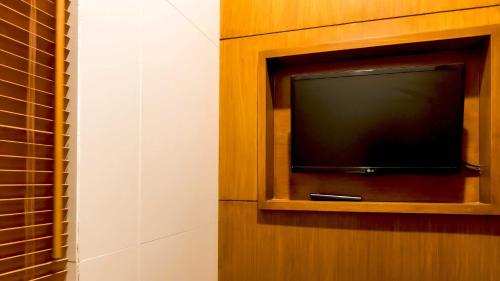 a flat screen tv in a wooden cabinet at DISINI Luxury Spa Villas-CHSE Certified in Seminyak