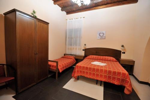 a hotel room with two beds and a cabinet at Hotel Piccolo in Termini Imerese