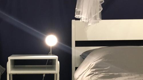 een lamp op een nachtkastje naast een bed bij Cozy Studio 10min to KLCC next to Hospital Gleneagle Jalan Ampang in Kuala Lumpur
