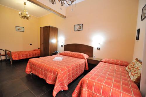 a hotel room with two beds and a chandelier at Hotel Piccolo in Termini Imerese