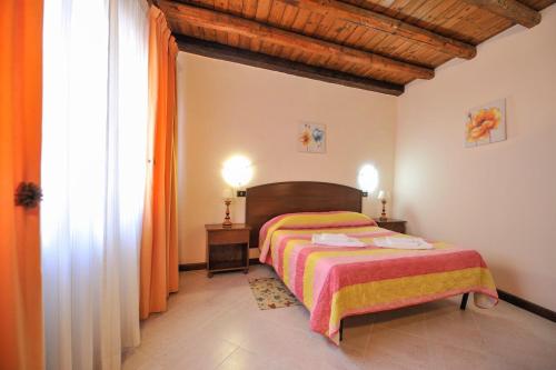 a bedroom with a bed with an orange blanket at Hotel Piccolo in Termini Imerese