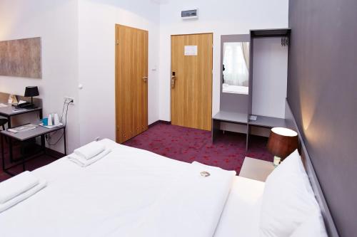 a hotel room with a bed and a desk and a desk at Koszary Arche Hotel in Góra Kalwaria