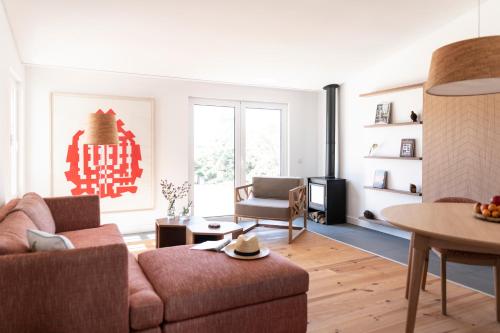 a living room with a couch and a table at Craveiral Farmhouse by Belong Staying & Feeling in São Teotónio