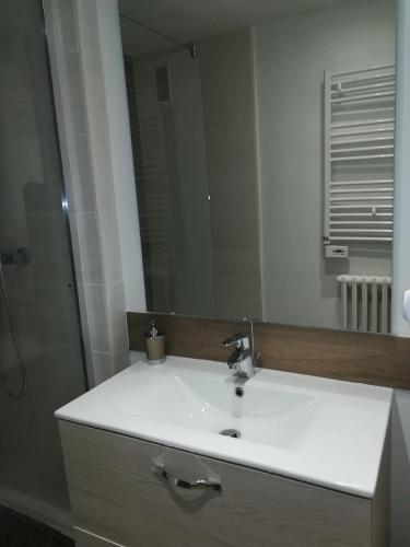 une salle de bain avec un lavabo blanc et un miroir dans l'établissement La Crochardière centre ville Le Mans, au Mans