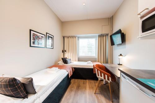 a hotel room with two beds and a desk at Forenom Aparthotel Espoo Leppävaara in Espoo