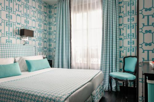 a bedroom with a bed and a chair and a window at Monceau Elysées in Paris