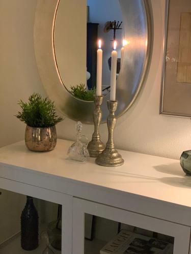 a table with two candles and a mirror on it at MilleBo - Like Home Studio Apartment in Aalborg