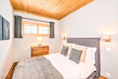 a bedroom with a bed and a wooden ceiling at Chalet Ourson Brun by Mrs Miggins in Grimentz