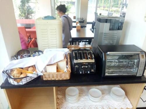 a counter with a toaster oven and a basket of bread at Butchard Villas in Yuchi