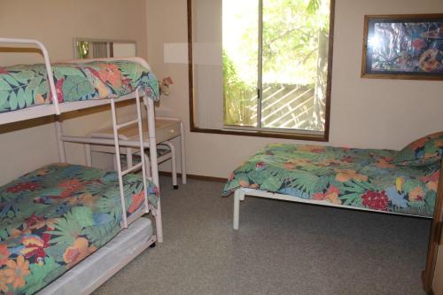 1 dormitorio con literas, escritorio y ventana en Coastal Retreat Unit 3, en Sunshine Bay