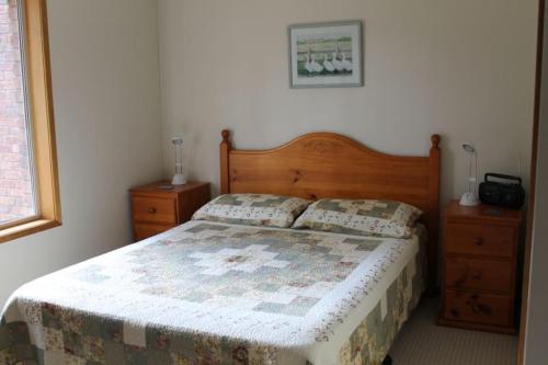 a bedroom with a bed and a dresser at Coastal Retreat Unit 5 in Sunshine Bay