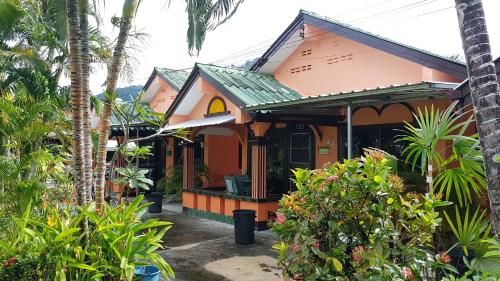 une maison au milieu d'un jardin avec des palmiers dans l'établissement Karon Homes, à Karon Beach