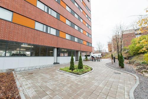 a brick building with a courtyard with trees at Forenom Aparthotel Espoo Leppävaara in Espoo