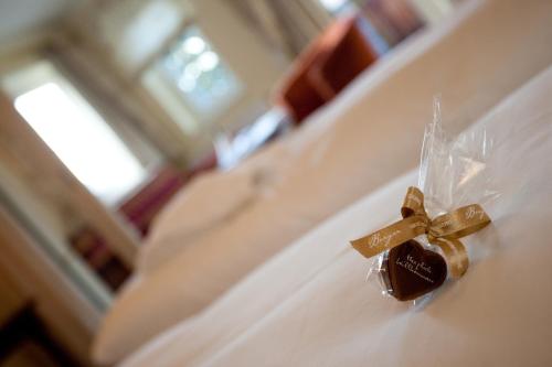 a piece of gold ribbon on a dresser with a gift at Hotel Seefischer - Finest Hideaway in Döbriach