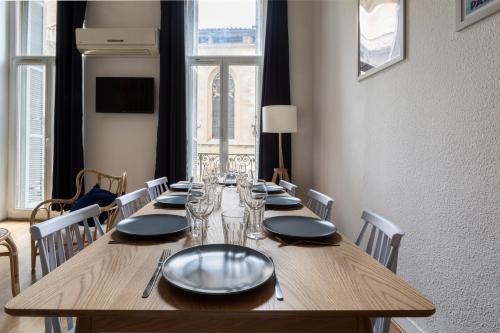 une longue table en bois avec des assiettes et des verres dessus dans l'établissement NOCNOC- L'Escale, à Marseille