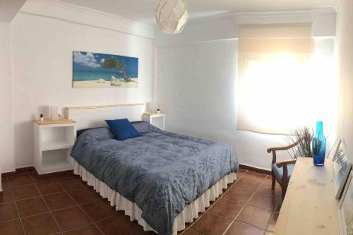 Piso en San Roque, centro neurálgico del Campo de Gibraltar في سان روكي: غرفة نوم بسرير وملاءات زرقاء ونافذة
