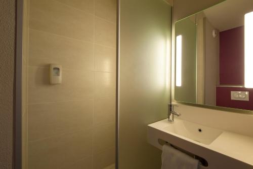 a bathroom with a shower and a sink and a mirror at B&B HOTEL Lyon Ouest Tassin in Tassin-la-Demi-Lune