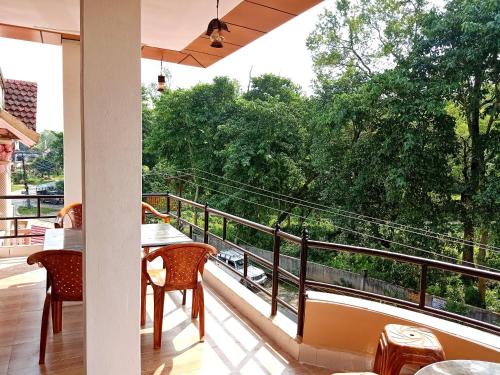 a balcony with tables and chairs and a view of trees at Hotel Rhinoceros-Homestay in Sauraha